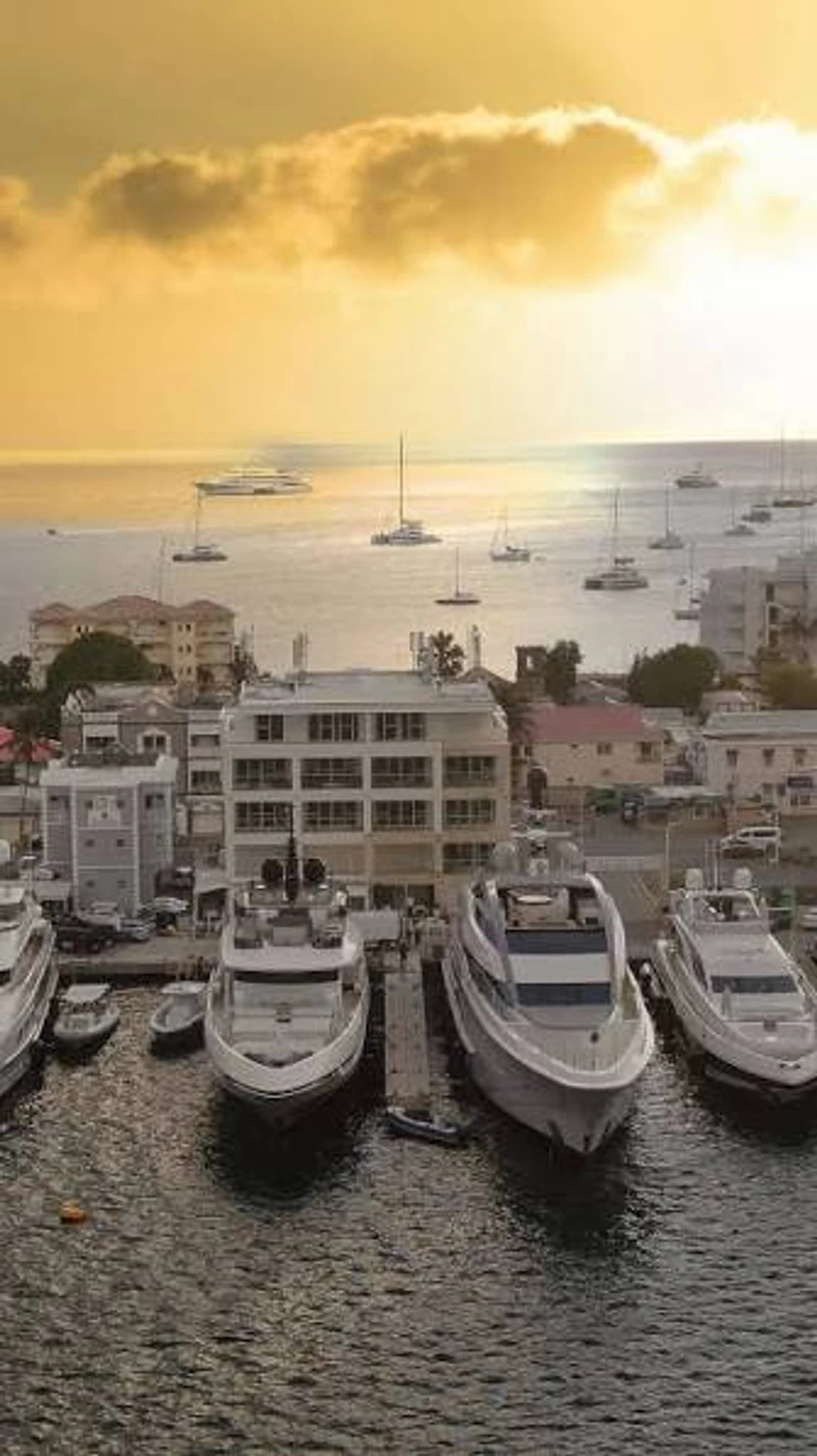 Superyachts moored at Skyport Marina in Simpson Bay at sunset